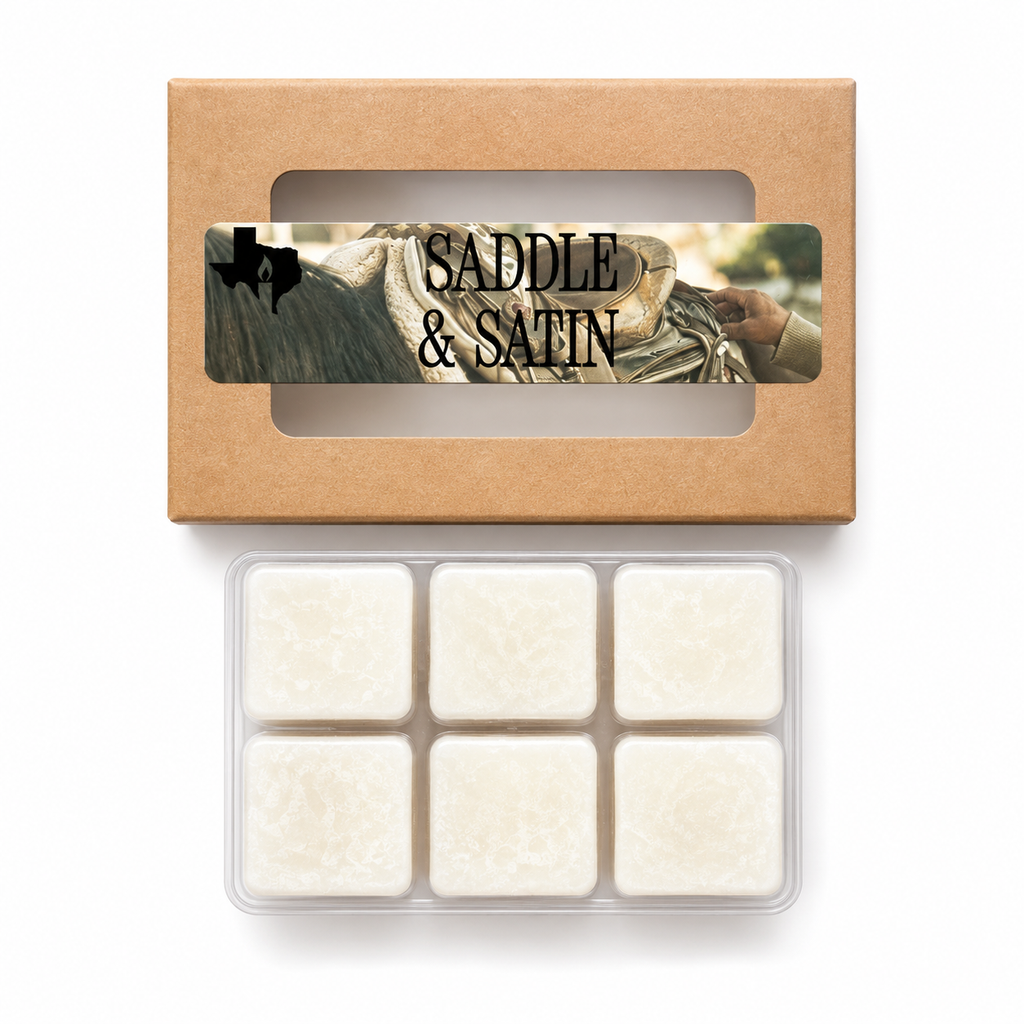 Saddle & Satin wax melts: kraft window box with leather-and-saddle label above an open clamshell of six white soy wax cubes