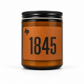 The 1845 8oz soy candle in an amber glass jar with a black lid and a leather label reading '1845', hand-poured by Texas Candles.