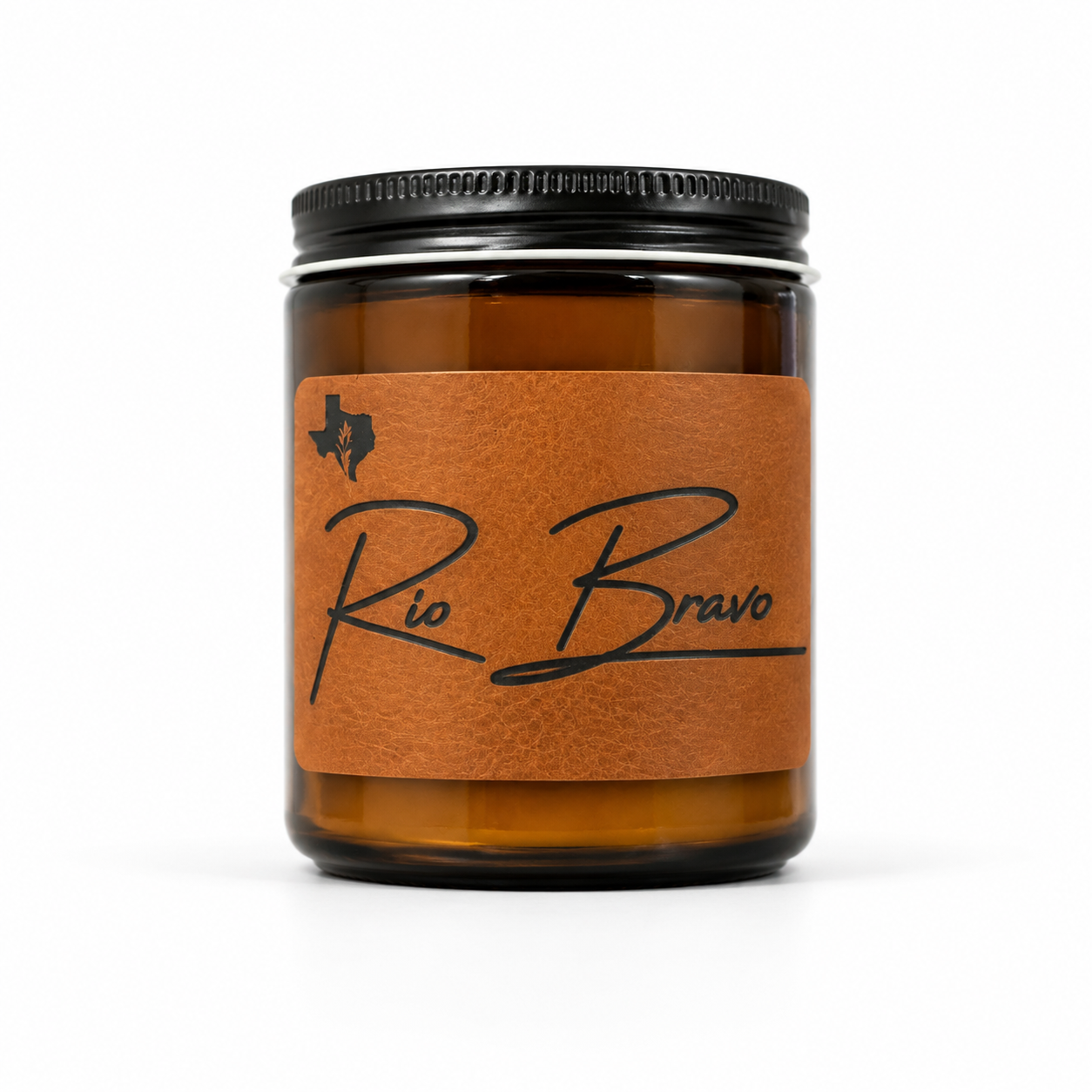 Rio Bravo 8oz soy candle in an amber glass jar with a black lid and a leather label with script lettering, on a white background.